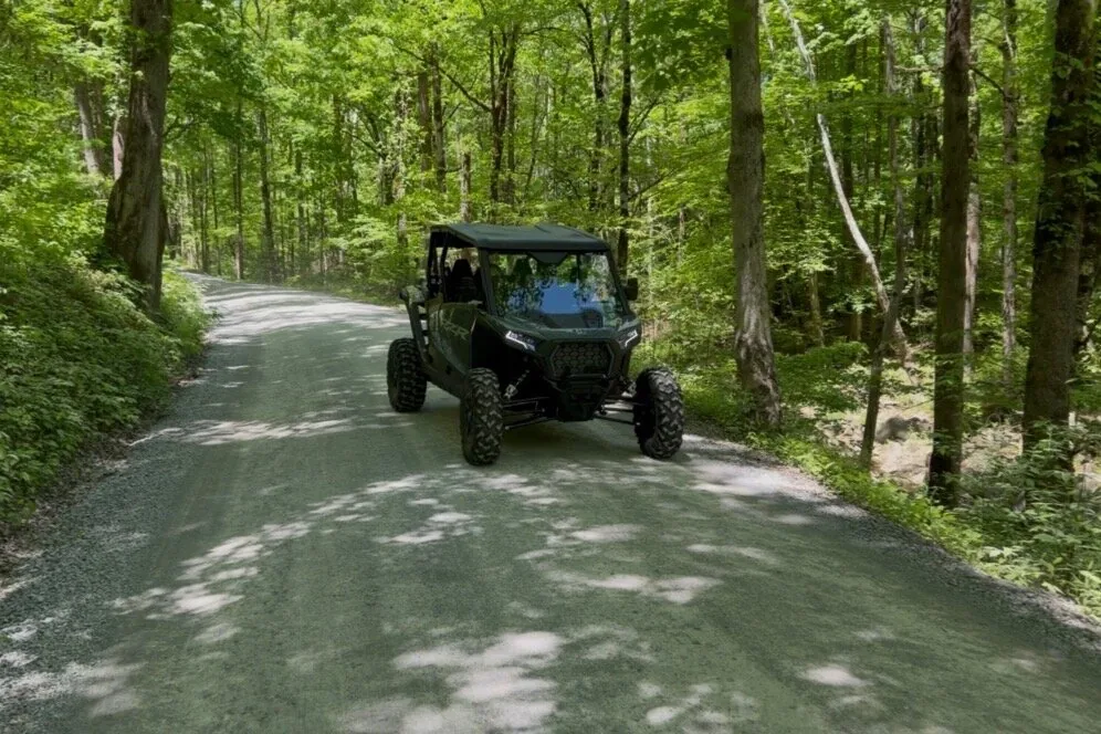 Rented UTV driving a gravel road through the Smoky Mountains forest